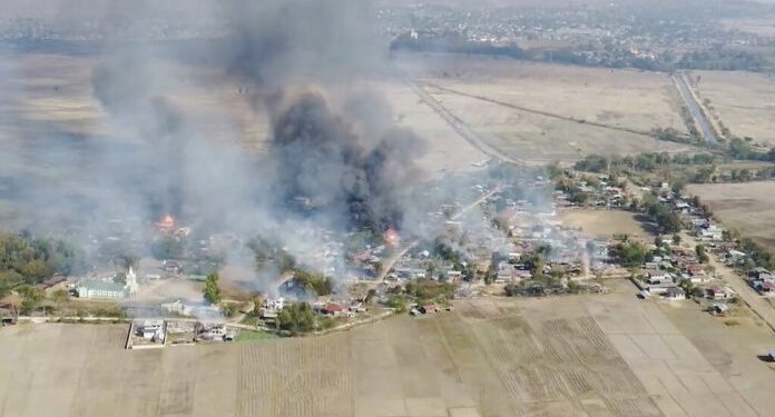 In this image taken from drone video provided by Free Burma Rangers, black smoke arises from burning buildings in Waraisuplia village in Kayah State, Myanmar on Feb. 18, 2022. While Russia’s war in Ukraine dominates global attention, Myanmar’s military is targeting civilians in air and ground attacks on a scale unmatched in the country since World War II, according to a longtime relief worker who spent almost three months in a combat zone in the Southeast Asian nation. (Free Burma Rangers via AP)